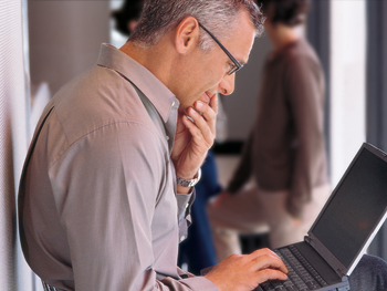 Photograph of a man using a laptop computer